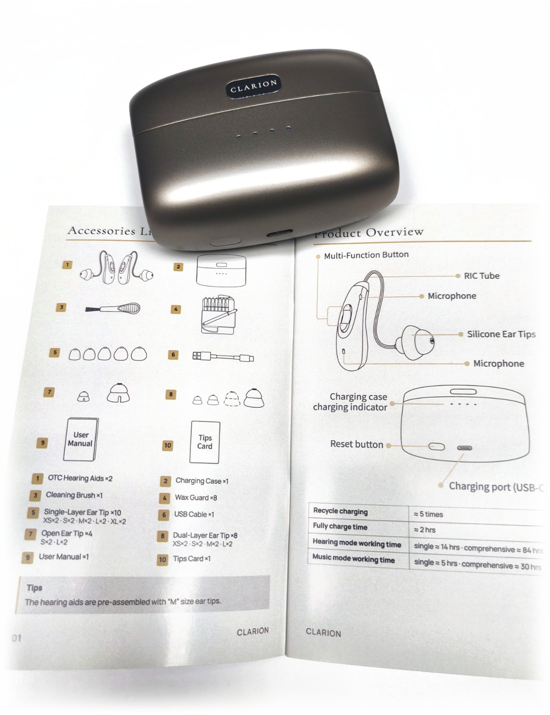 The charging case resting on the printed user manual, open at the product overview.